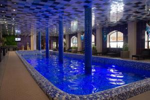 a large pool with blue water in a building at Vyshegrad Castle Hotel in Vyshhorod