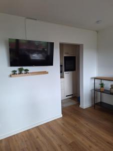 a living room with a flat screen tv on a wall at Ferienwohnung Allgäuerle 1605 Ski in Ski out an der Skipiste mit Hallenbad Sauna und Tiefgarage in Missen-Wilhams +42 photos