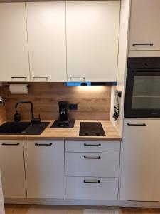 a kitchen with white cabinets and a stove top oven at Ferienwohnung Allgäuerle 1605 Ski in Ski out an der Skipiste mit Hallenbad Sauna und Tiefgarage in Missen-Wilhams