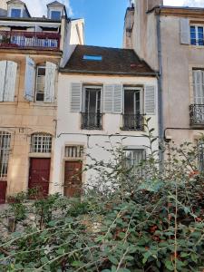 an old white building with windows and balconies at Maison Rinette in Dijon