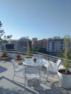 a patio with a table and chairs on a balcony at Sky Santa Cruz Penthouse in Santa Cruz de Tenerife