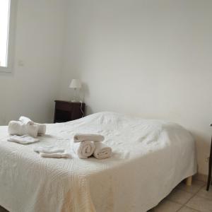 a white bed with towels on top of it at Maison à la plage.7 couchages in Borgo
