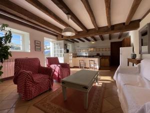 a living room with chairs and a table and a kitchen at Ferme uhartea in Sare