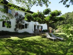 a white house with a bench in the yard at Ferme uhartea in Sare