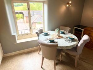 a dining room with a table and chairs and a window at Countryside converted barn with hot tub and one parking space in Newton Abbot