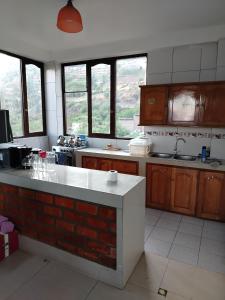 a kitchen with a counter and some windows in it at Casa de Campo Apu San Isidro in Urubamba