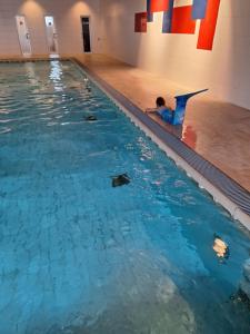 a boy laying on the side of a swimming pool at Ferienwohnung Allgäuerle 1605 Ski in Ski out an der Skipiste mit Hallenbad Sauna und Tiefgarage in Missen-Wilhams