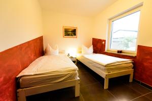 2 Betten in einem Zimmer mit Fenster in der Unterkunft Spreewaldferienhäuser am Deich in Lübben