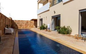 an infinity pool with blue water in a house at The Ocean Surf Villa in Dakhla