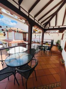 Un patio con mesas y sillas en un balcón. en Hotel Aamayu, en Villa de Leyva