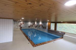 a swimming pool in a house with a wooden ceiling at Petit havre de paix! in Les Collons