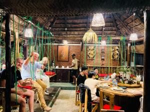 a group of people sitting at tables in a restaurant at Villa Rosa in Moshi