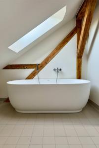 a large white bath tub in a attic at Gesamtes Historisches Kapitänshaus in Fehmarn +84 photos
