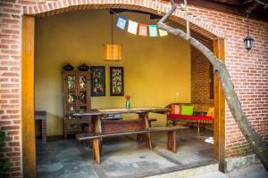 a patio with a wooden table and a bench at Eco Suíte Jatobá Natureza Conforto e Paz in Pirenópolis +13 photos