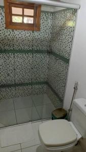 a bathroom with a toilet and a glass shower at Eco Suíte Jatobá Natureza Conforto e Paz in Pirenópolis