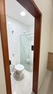 a bathroom with a toilet and a glass shower at Casa Familiar in Aparecida +20 photos