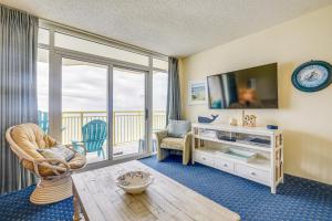a living room with a large window and a tv at 2 Mi to Barefoot Landing Condo with Beach Access! in Myrtle Beach