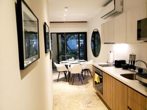 une cuisine et une salle à manger avec une table et des chaises dans l'établissement Ipana Condos by HA, à Playa del Carmen