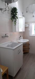a white bathroom with a sink and a mirror at Casa Nannina in Matera +18 photos