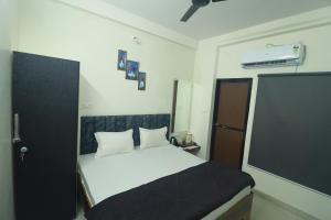 a bedroom with a bed with a black and white comforter at Ujjain Sparsh Stays in Ujjain