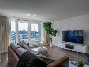 a living room with a couch and a flat screen tv at Coastal Charm - min 3-Day Stay Breathtaking Views with Work Desk by Victoria Prime! in Victoria