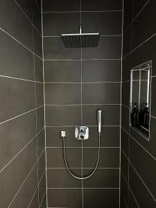 a shower with a hose in a black bathroom at Luxuriöse Penthousewohnung in der Quakenbrücker Altstadt in Quakenbrück