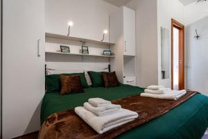 a bedroom with a green bed with towels on it at Roma centro pochi minuti - Appartamento con giardino privato in Rome