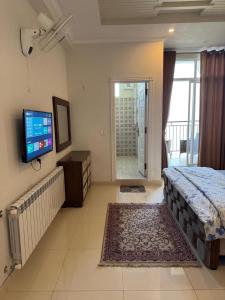 a bedroom with a bed and a flat screen tv at Serenity Suites in Bhurban