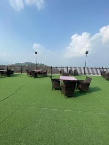 a group of picnic tables and benches on a field at Serenity Suites in Bhurban