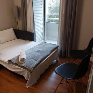 圣保罗Flat confortável próx Ibirapuera e Jardins com garagem的一间卧室，里面有一张床、一把椅子和一扇窗户