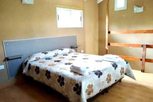 a bedroom with a bed with a blanket on it at Los Laureles de Sorso in Villa Ciudad Parque