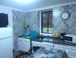 Casa Juan في Santa Olaja de Eslonza: مطبخ مع طاولة وساعة على الحائط