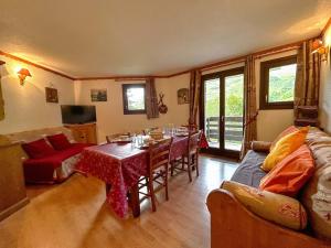 a living room with a table and a couch at Appartement montagne 6 pers, rénové, balcon sud/ouest - FR-1-452-389 in Les Menuires