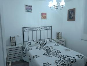 Casa Juan في Santa Olaja de Eslonza: غرفة نوم بسرير اسود وبيض وجلستين نوم