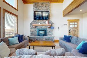 a living room with a couch and a fireplace at Eagle Feather Lookout in Garden City