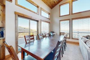 a dining room with a table and chairs and windows at Eagle Feather Lookout in Garden City