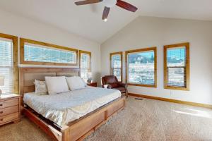 a bedroom with a bed and a chair and windows at Eagle Feather Lookout in Garden City