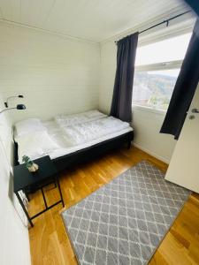 a small bedroom with a bed and a window at Fjellsporthytta nr. 4 in Sogndal
