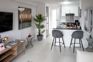 开普敦Centurion 207 Luxury Sea Point one bedroom apartment with access to magnificent pool Perfect location by Super Host Melvyn的配有两张吧台凳和一张柜台的厨房