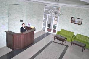 a woman standing at a podium in a waiting room at Sharm Hotel in Glodeni