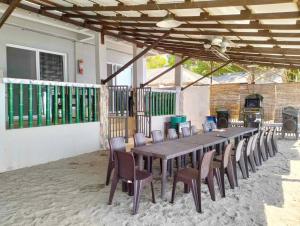 a long wooden table and chairs in a patio at Caleboat Beach Resort in Kalooñgan