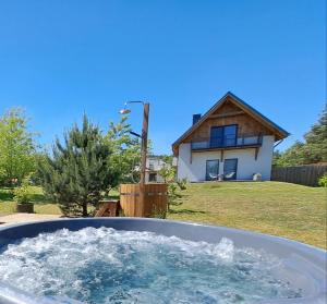 a bath tub filled with water in front of a house at 4 Pokoje Swory in Swornegacie 
