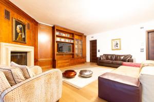 Una sala de estar con un sofá y un televisor. en Villa Adige Luxury - M&M Holiday House, en Perugia