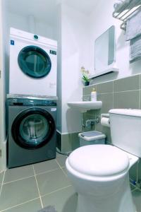 a bathroom with a washing machine next to a toilet at Palawan Cozy 2BR w Washer, Dryer, Gym, Pool for 6 in Puerto Princesa City