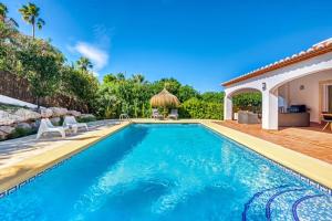 a swimming pool in a yard with a house at Casa Las Lunas Javea in El Tosalet