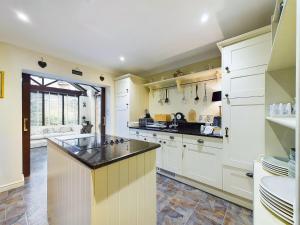 a kitchen with white cabinets and a black counter top at Rokeby in Bamburgh