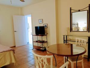 a living room with a table and a television at Villa Tranquilla in Estepona