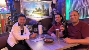 three people sitting at a table with a bottle of wine at Hotel Alte Wache in Mariental +18 photos