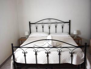 a bedroom with a black and white bed with white sheets at Villa Mimì in Ostuni