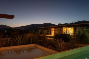 a house with a pool in front of it at Hotel Los Amantes Valle de Guadalupe in Valle de Guadalupe